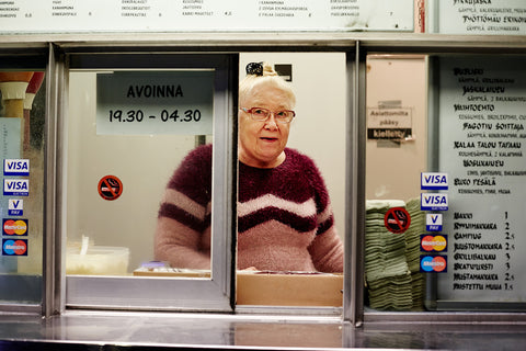 A woman looks through the window of Jaskan Grilli, a snägäri food truck in Töölö, Helsinki