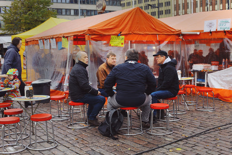 A group of men share a meal in the orange tents (torikahvilat) of Helsinki's market square