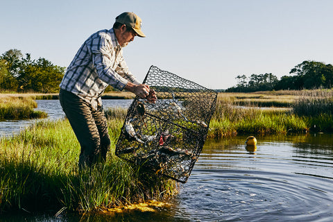 A man in the Lowcountry of South Carolina pulls a crab trap out of the plough mud