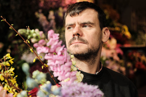 A portrait of florist Mark Colle holding a bouquet of flowers at his shop in Antwerp, Belgium