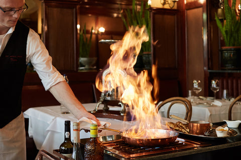 A waiter holds a flaming pan of crêpes
suzette at Au Vieux Port French bistro in Antwerp, Belgium