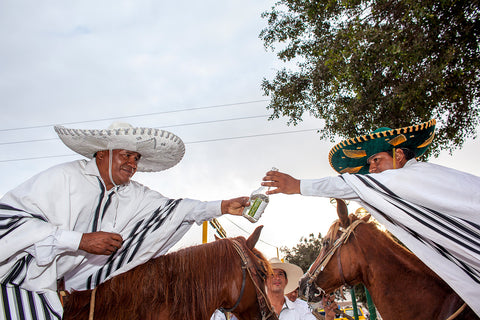 Two men on horseback share pisco at Peru’s oldest bodega, La Caravedo, near Lima, Peru