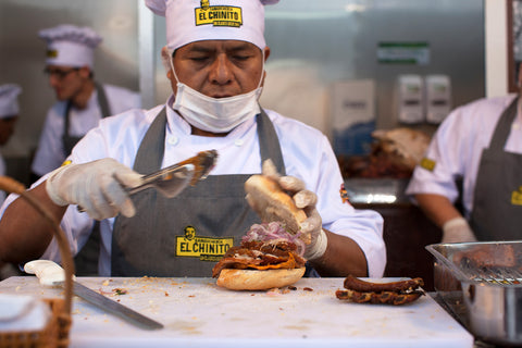 A chef assembles a pork sandwich at El Chinito in Lima, Peru