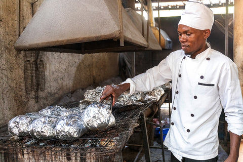 A chef at Luwombo cooks meat in banana leaves in Kampala, Uganda