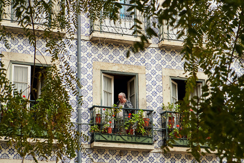 A man stands on a tiled balcony in Lisbon, Portugal