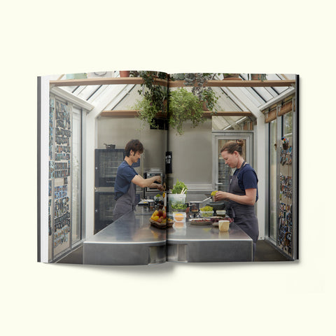 An interior spread of Fare magazine's Copenhagen, Denmark city guide, featuring a photograph of two chefs developing recipes in noma's test kitchen