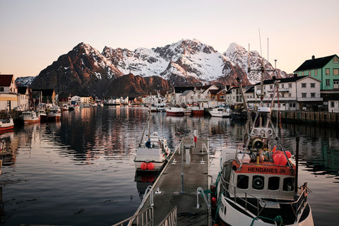 Boats in the harbour in North Norway surrounded by a snowy winter mountain landscape